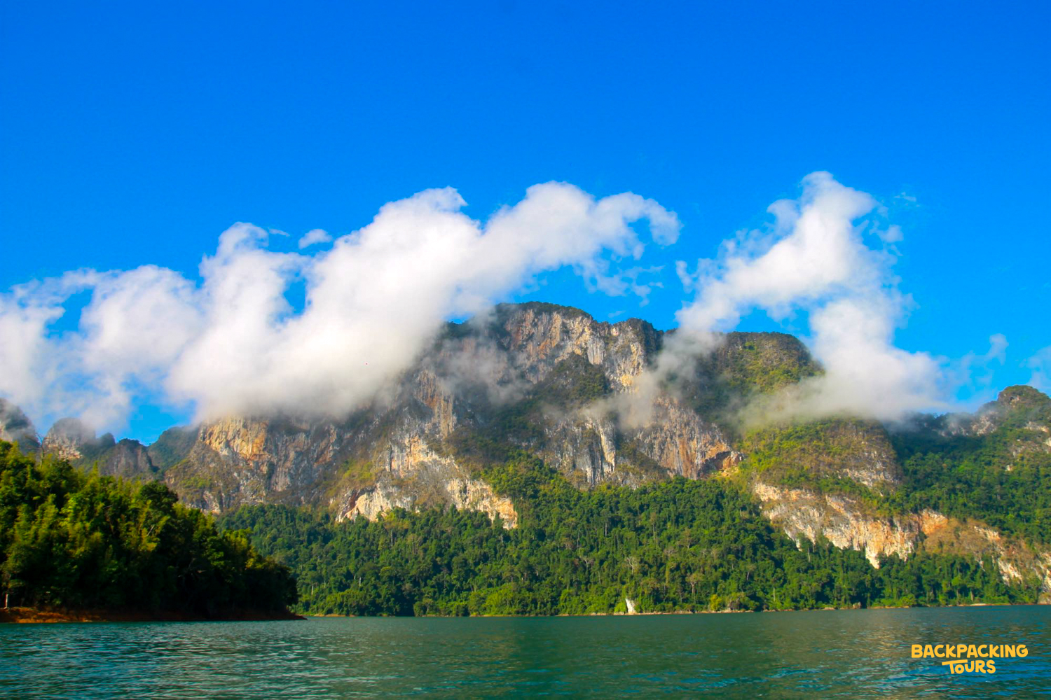 Towering limestone karsts rise from the emerald waters of Cheow Lan Lake in Khao Sok National Park.