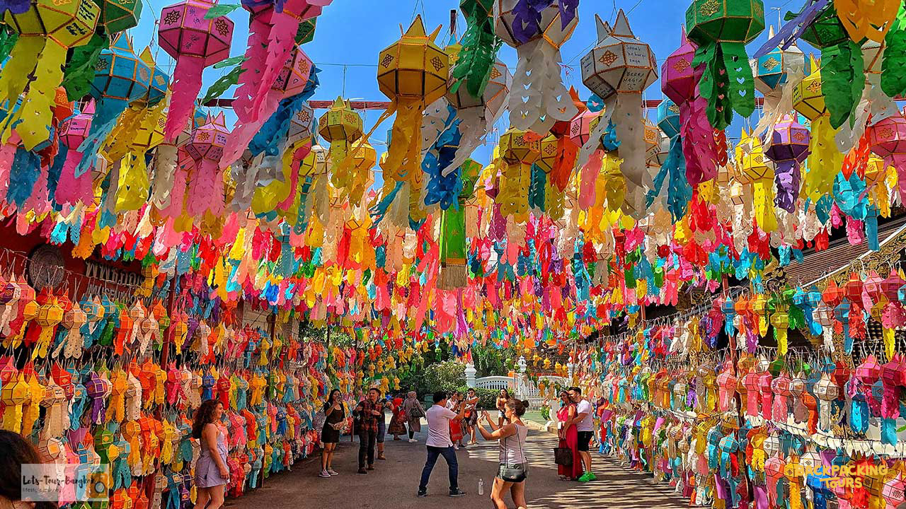 A vibrant street in Chiang Mai adorned with thousands of colorful paper lanterns and festive decorations.