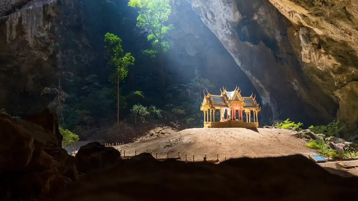 Sunlight illuminates a beautiful golden pavilion nestled inside Phraya Nakhon Cave in Thailand.