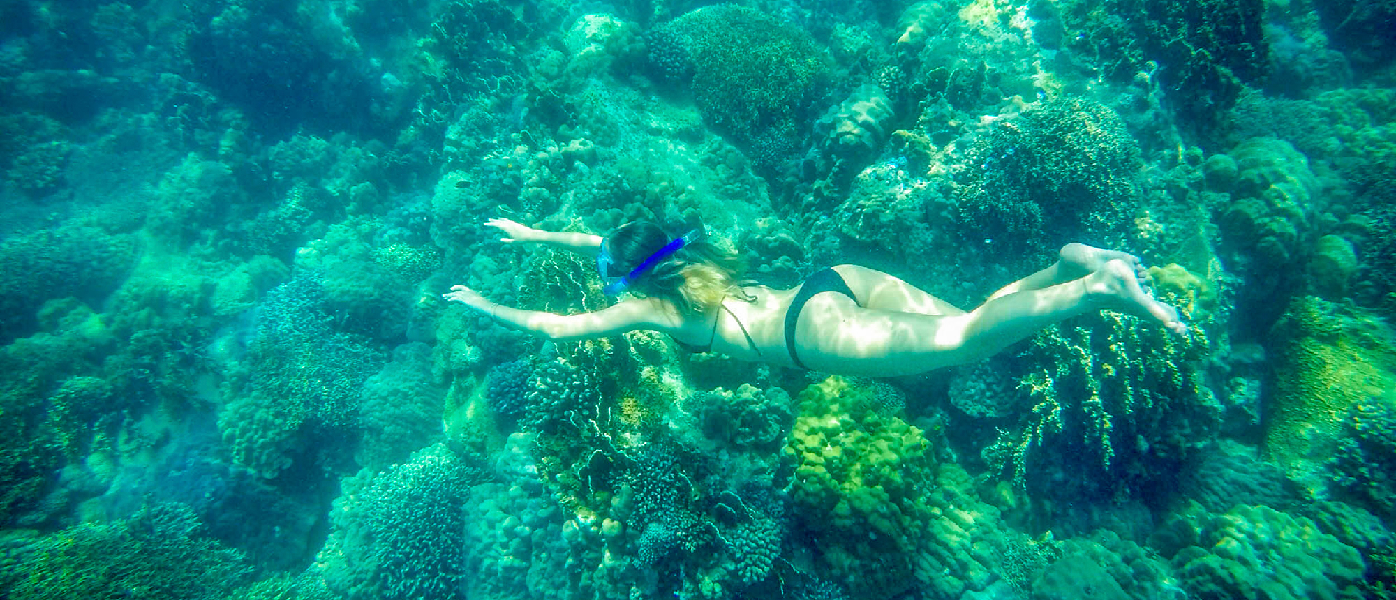 A woman snorkeling among beautiful coral formations in the clear waters near Nha Trang.