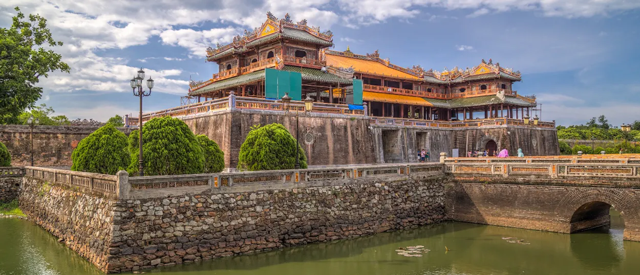 Ornate imperial citadel with traditional architecture, surrounded by a moat and stone bridge in Hue.