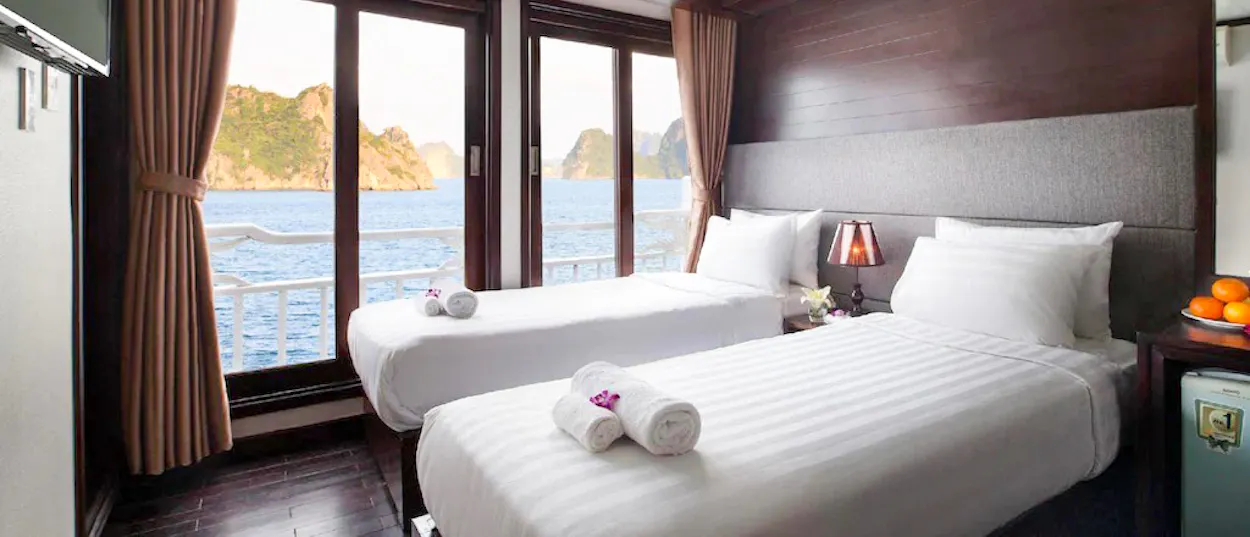 A comfortable boat cabin with two beds overlooking the stunning limestone karsts of Ha Long Bay.