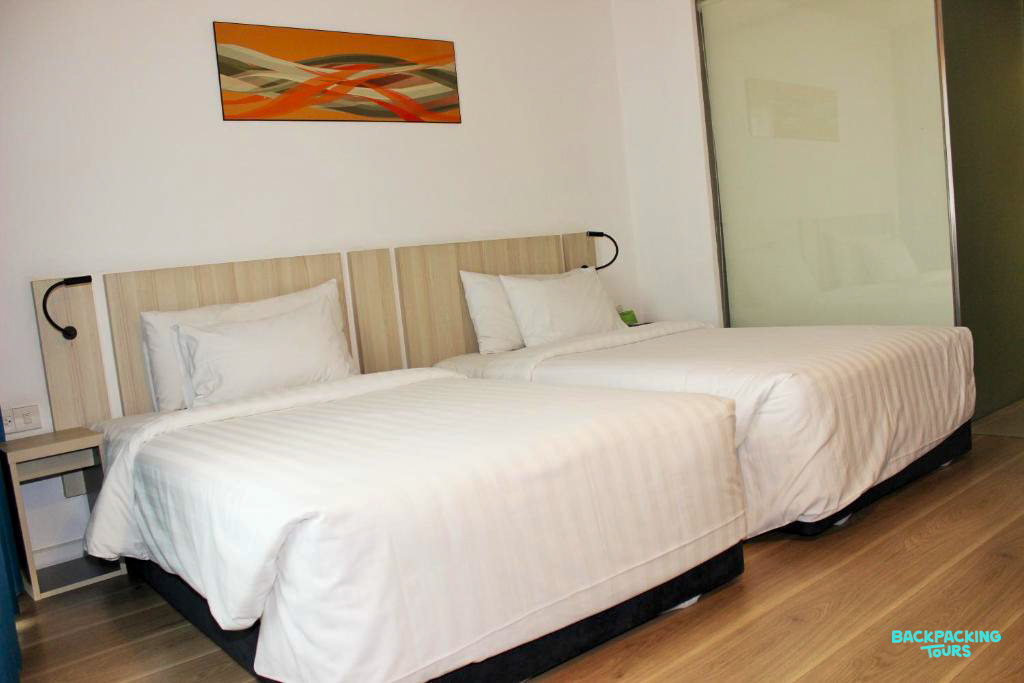 Comfortable twin beds in a bright, modern hotel room in Ho Chi Minh City.