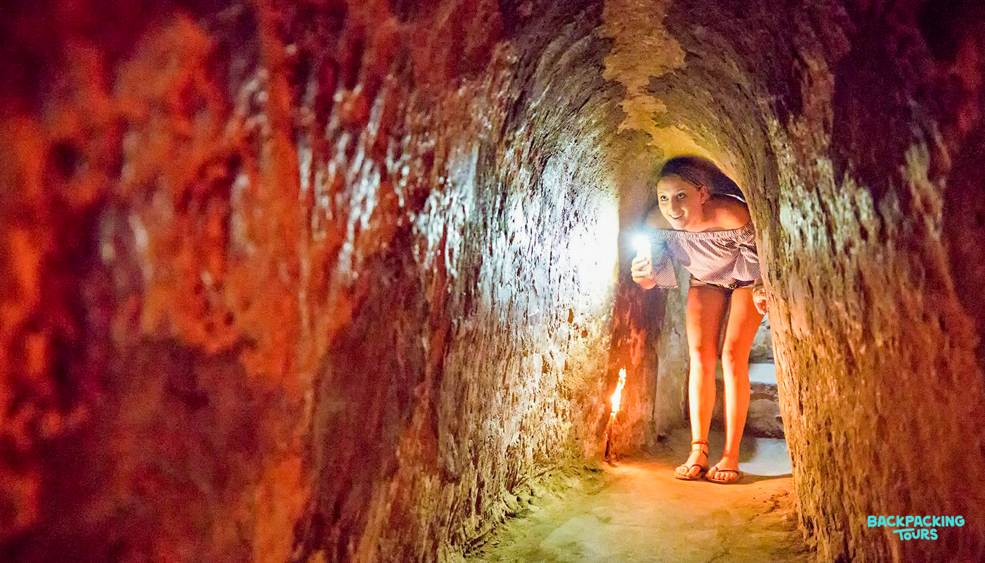A traveler uses a flashlight to navigate the historic Cu Chi Tunnels near Ho Chi Minh City.