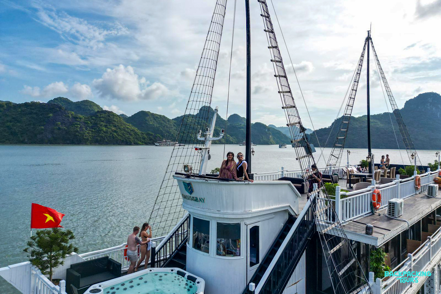 Travelers enjoy a scenic overnight cruise on a traditional boat through the stunning limestone karsts of Ha Long Bay.