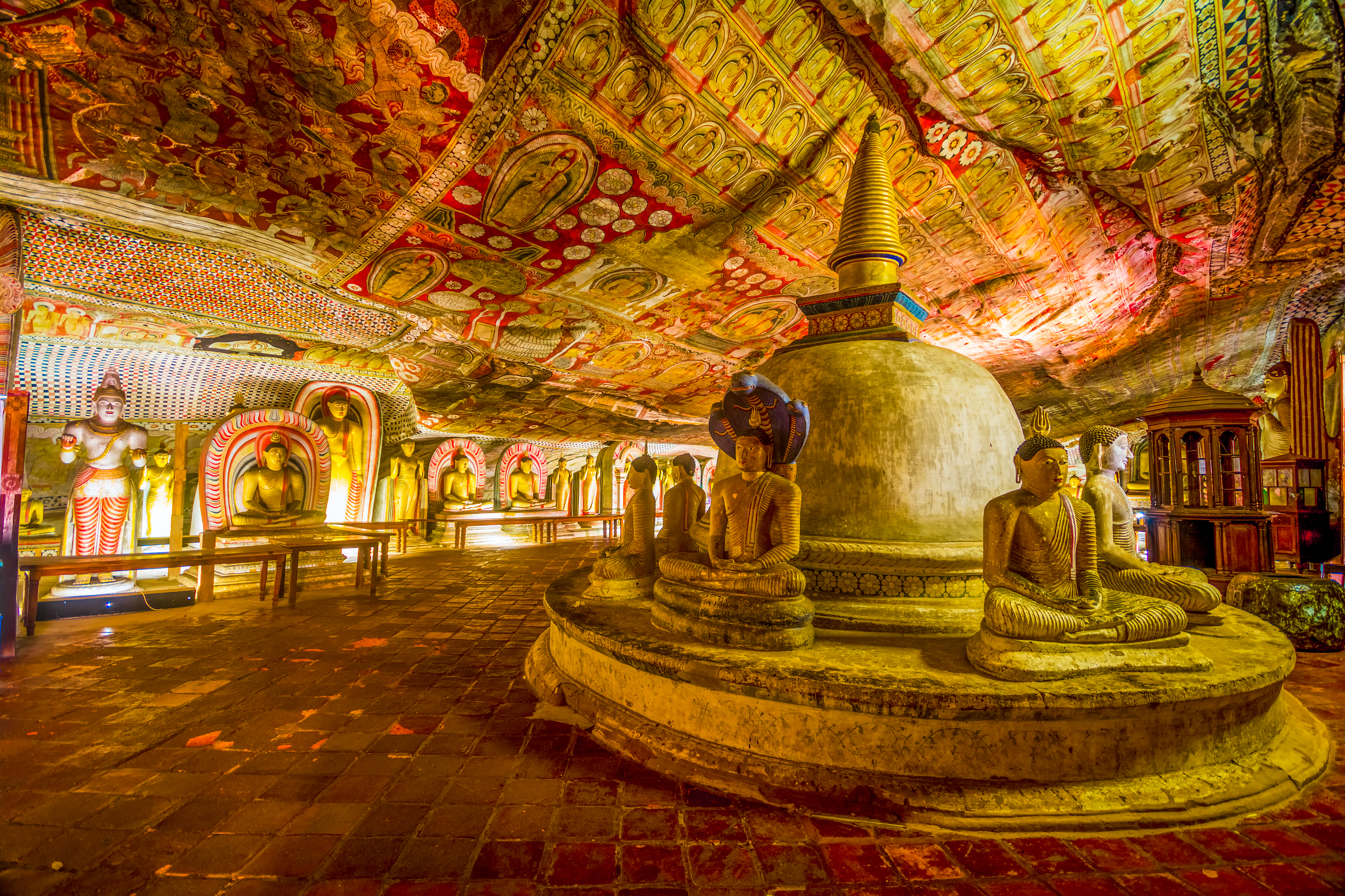 Elaborate painted ceilings and many Buddha statues inside the sacred Dambulla Cave Temple in Sri Lanka.