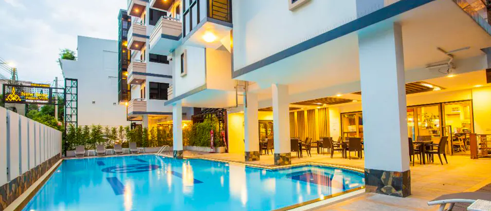 Modern hotel with a bright swimming pool and an inviting outdoor dining area in Thailand.