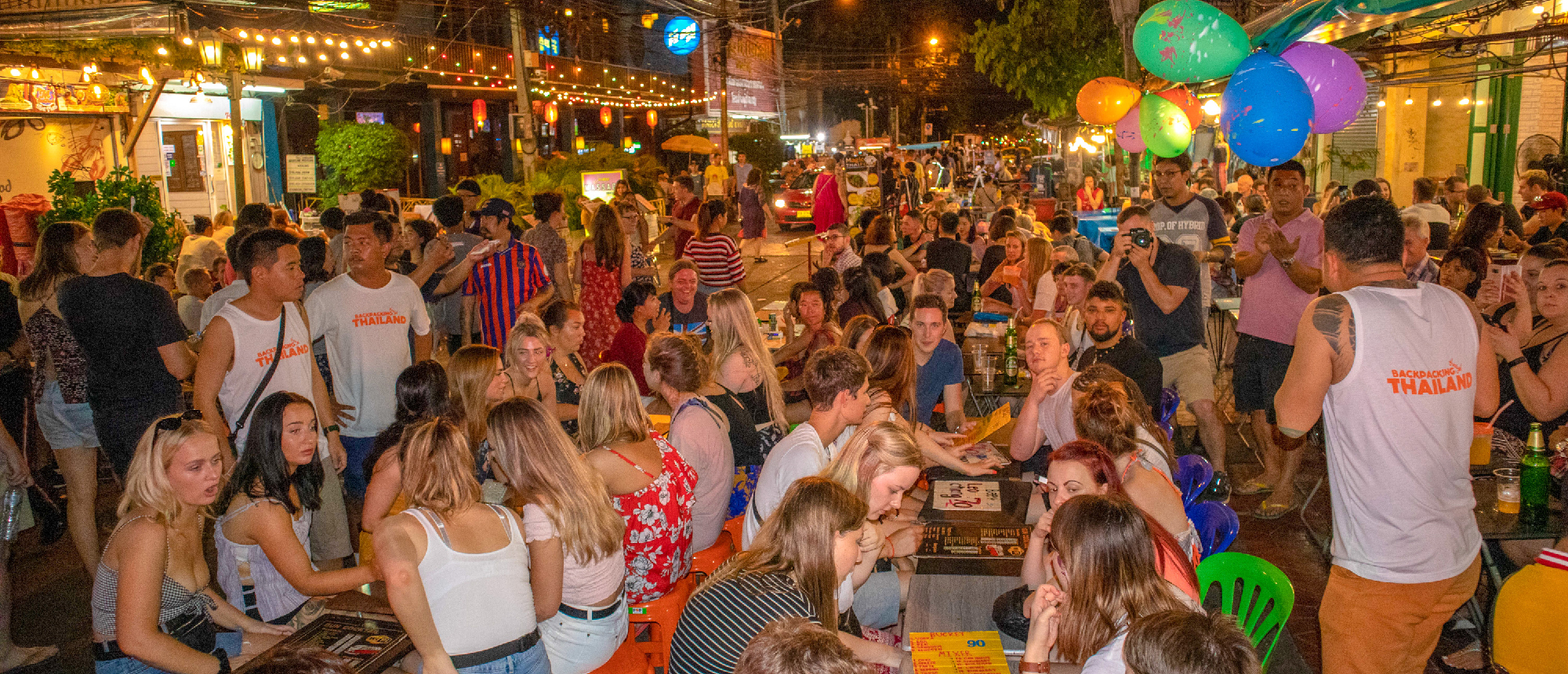 Backpackers and locals enjoying a festive night out on the bustling Khao San Road in Bangkok.