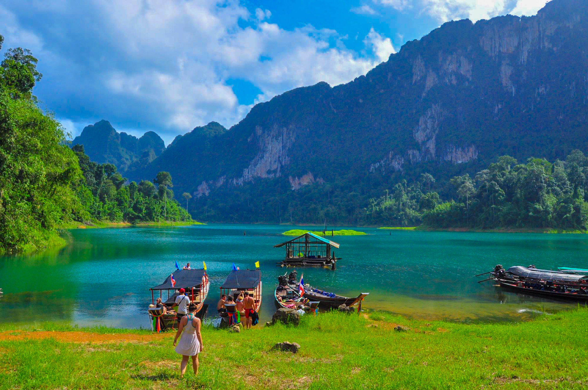 Tourists prepare to board longtail boats on Cheow Lan Lake, Khao Sok, amidst dramatic karsts.